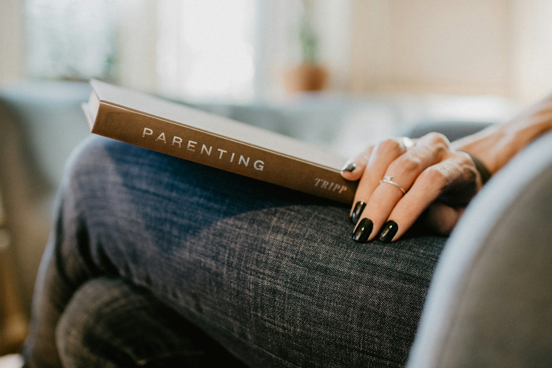 kelly-sikkema-giijfNulwxk-unsplash holding parenting book