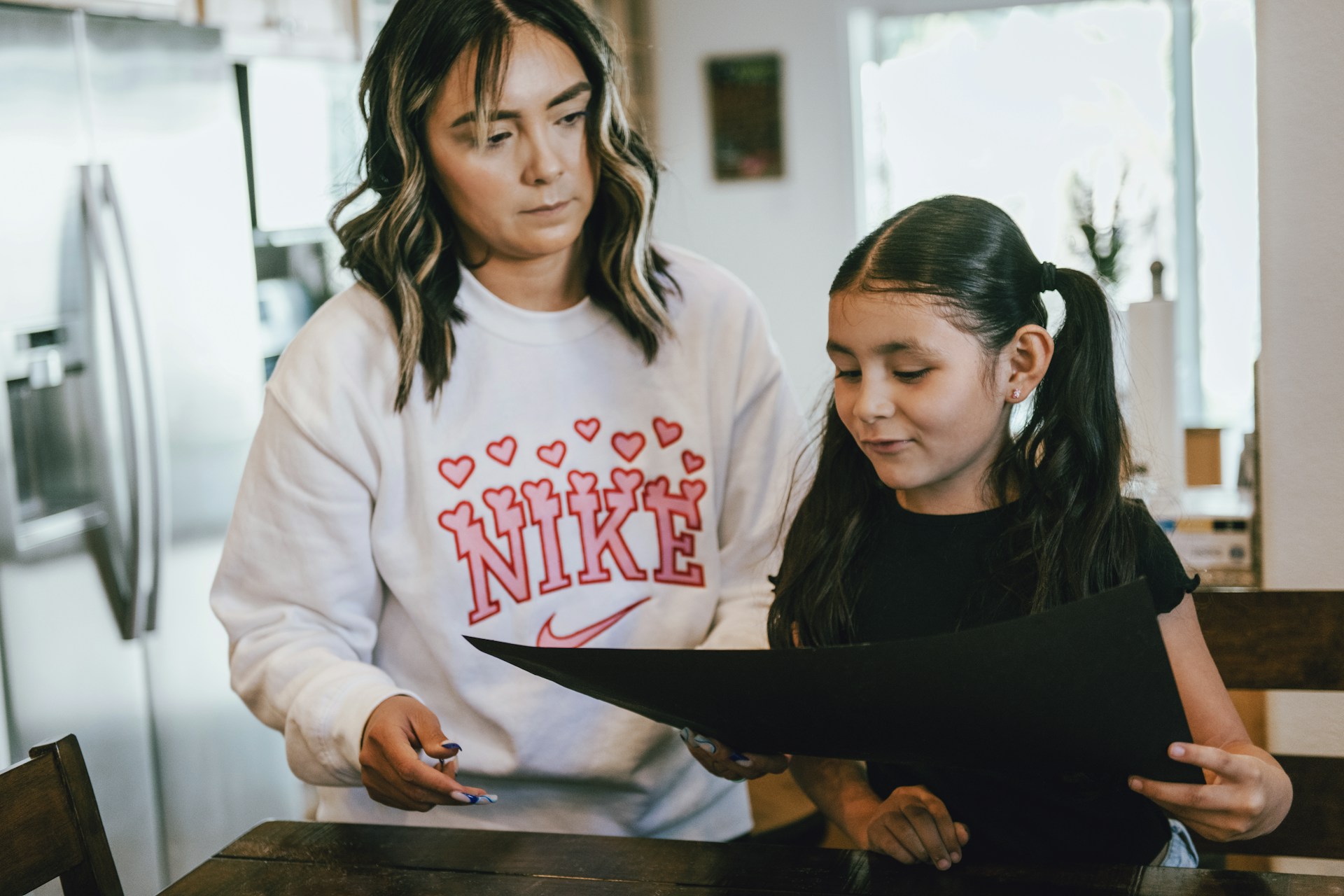 tim-mossholder-0vWMHOtXnao-unsplash mother looking at daughter's school work